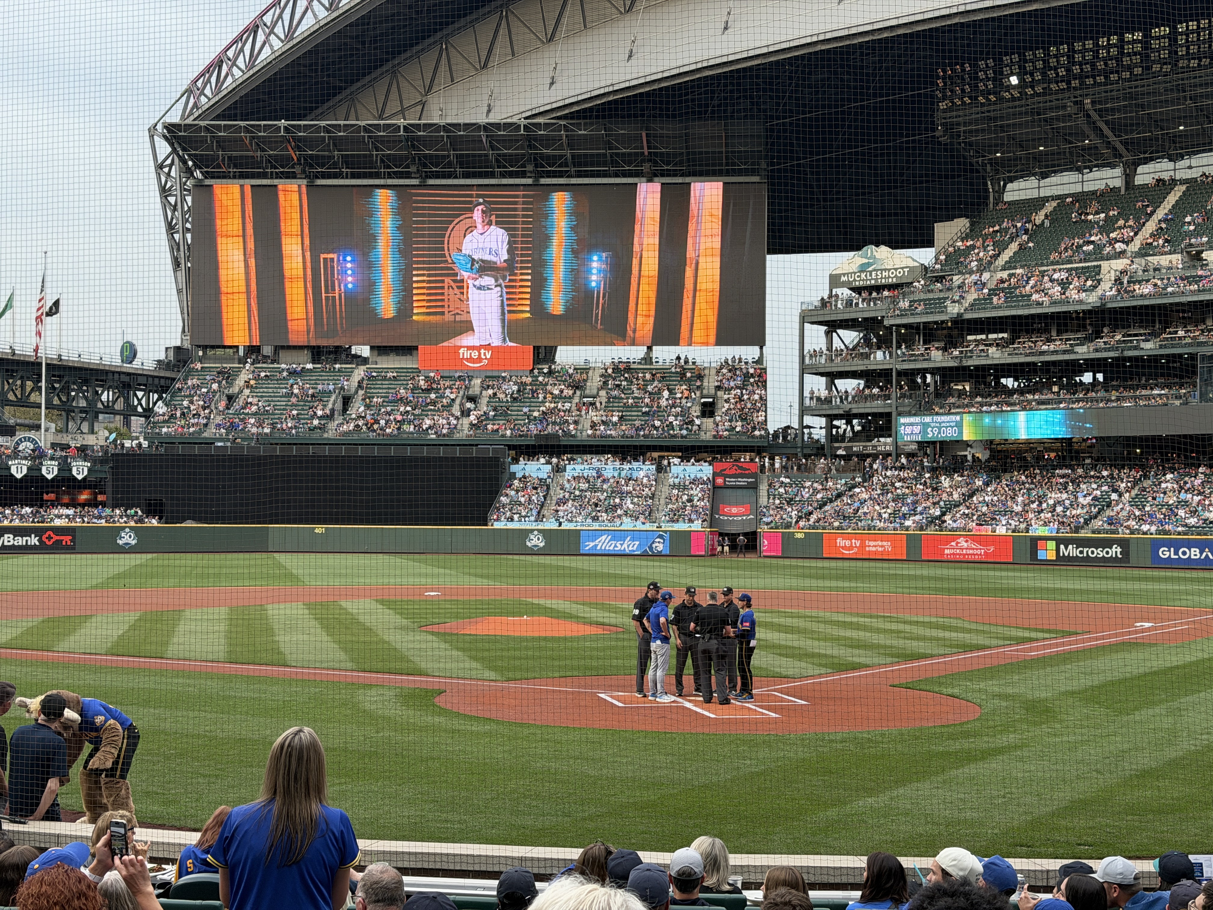 Umpires and coaches meeting at home plate before first pitch.